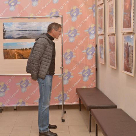 Сергей Загайнов, участник фотоклуба, знакомится с выставкой Колотилова.